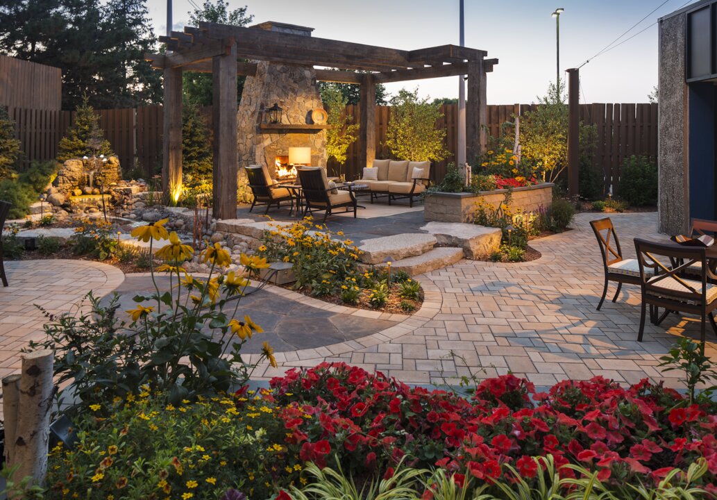 Cozy backyard patio with fireplace and garden flowers.