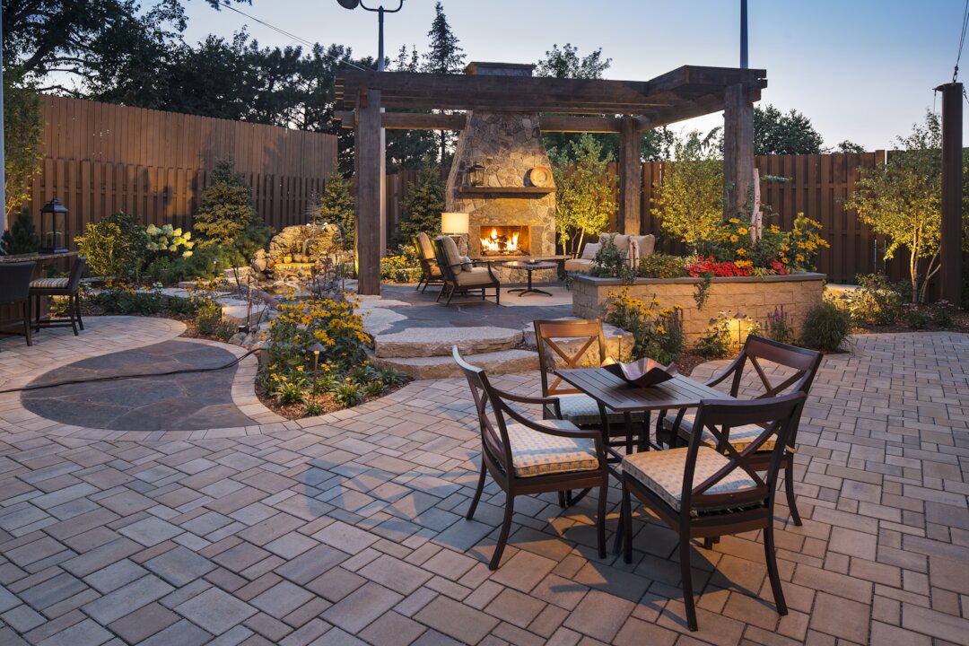 Cozy patio with fireplace and garden at dusk.