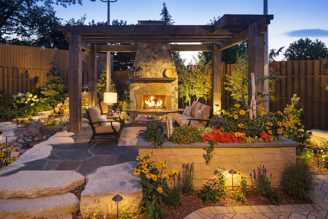 Cozy outdoor patio with fireplace and garden.