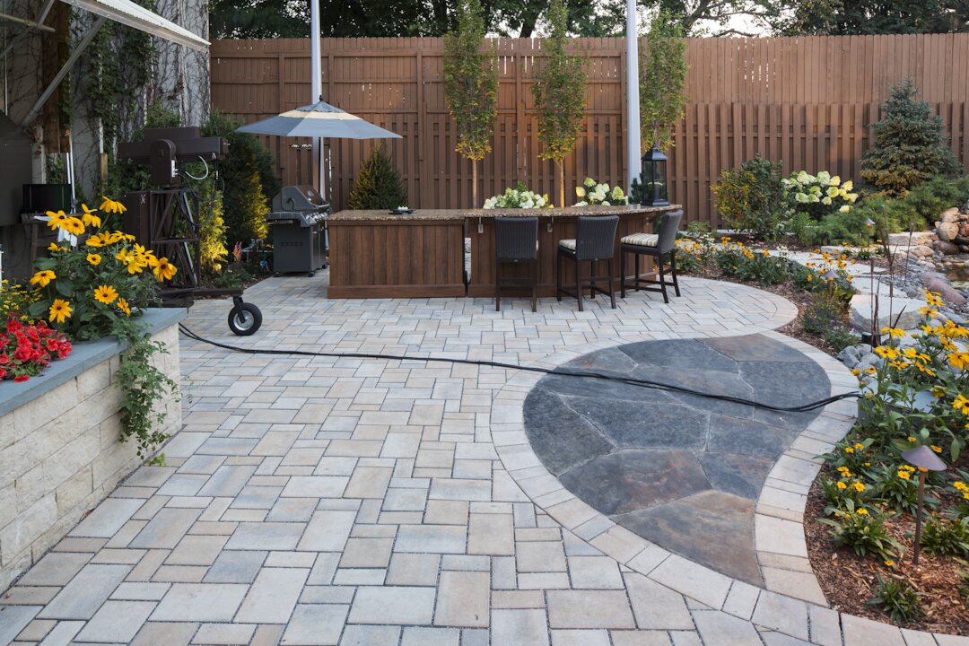 Elegant backyard patio with seating and grill.
