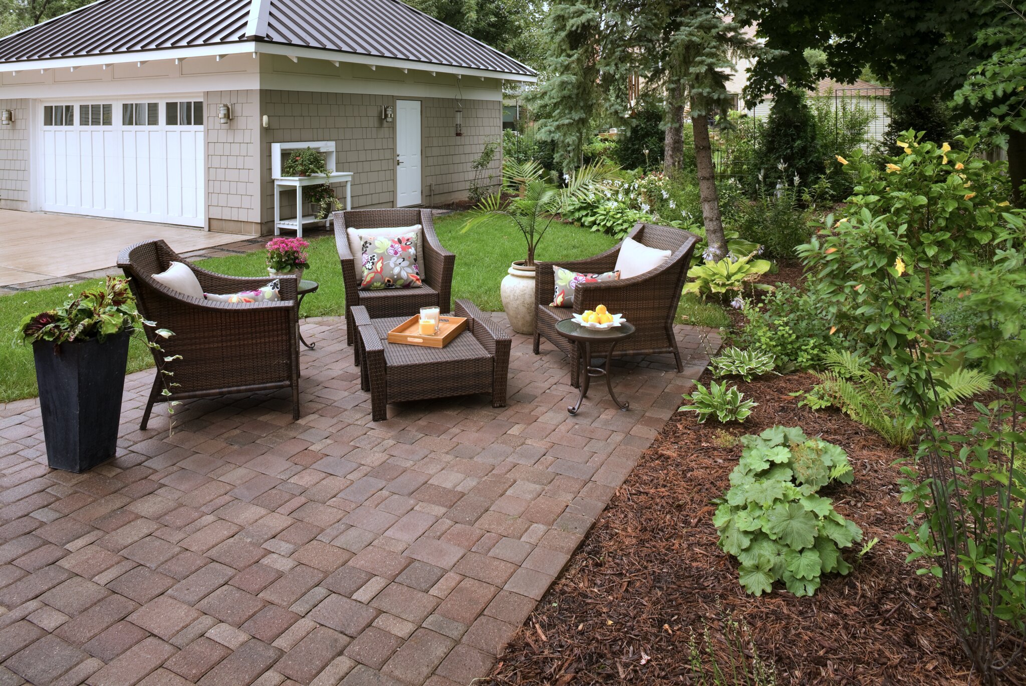 Cozy patio with wicker chairs and plants.