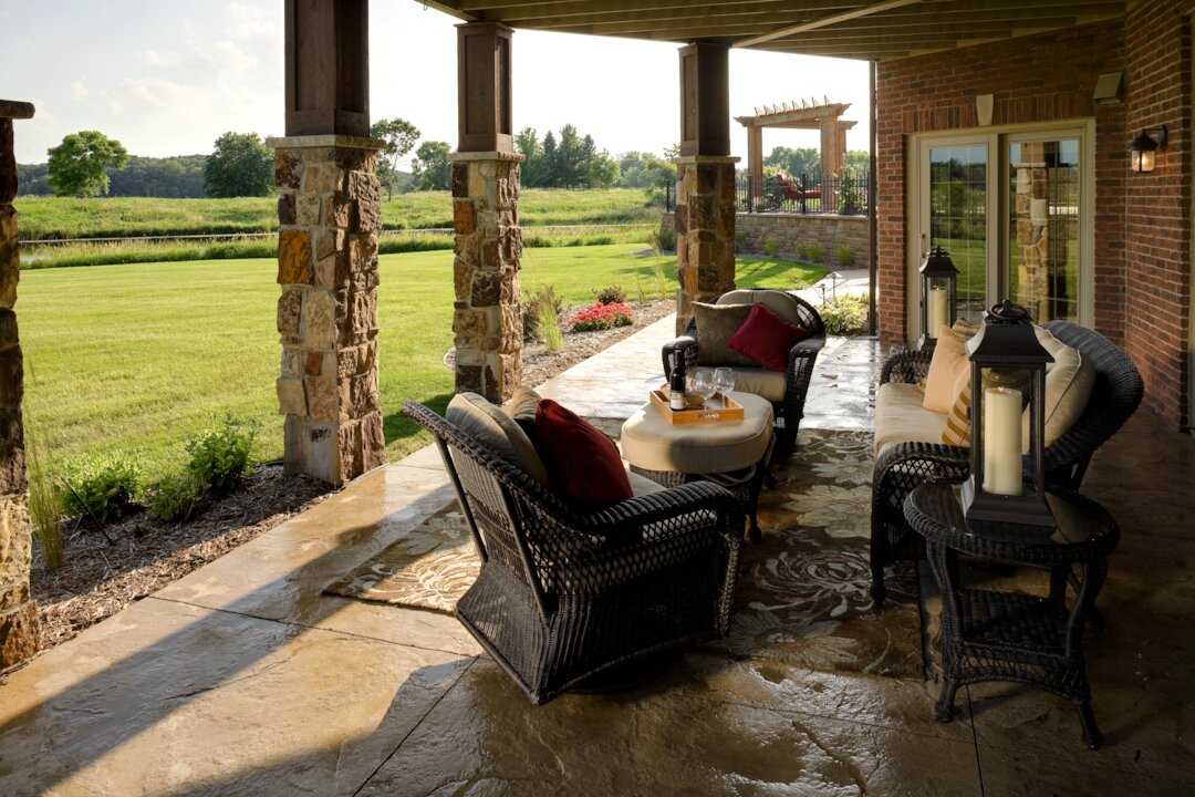 Cozy patio with wicker furniture and garden view.