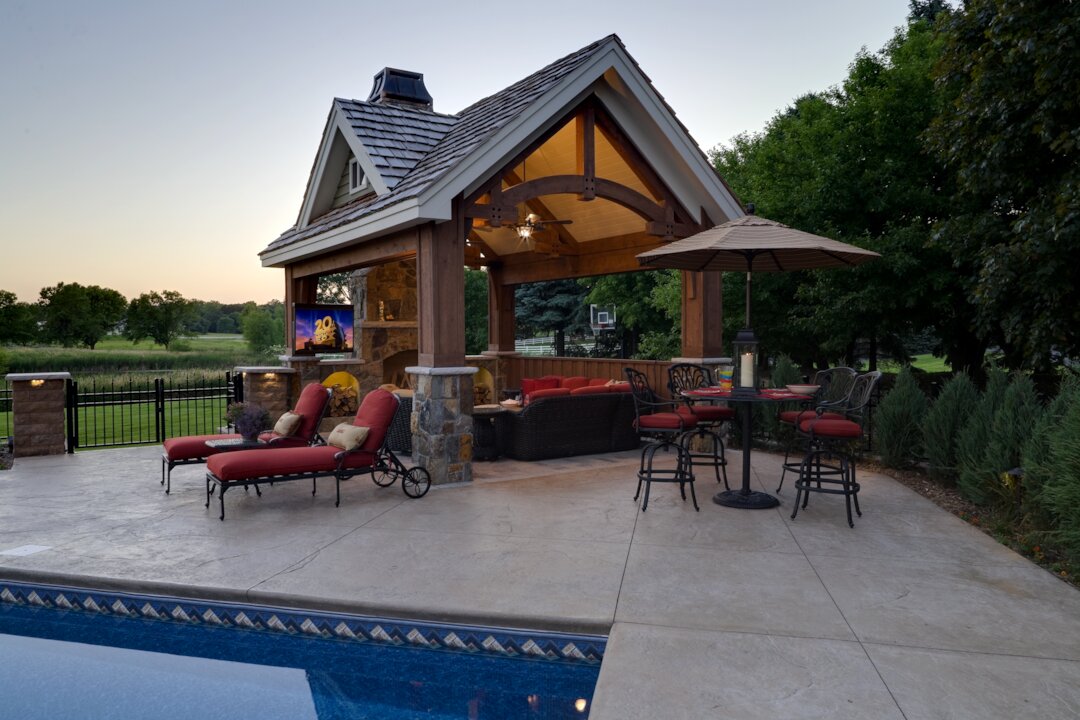 Outdoor patio with cabana, furniture, and poolside view.