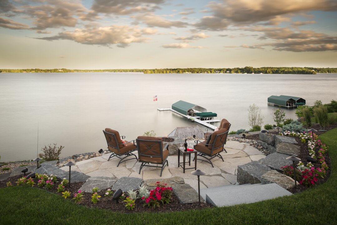 Lakeside patio with chairs and dock view