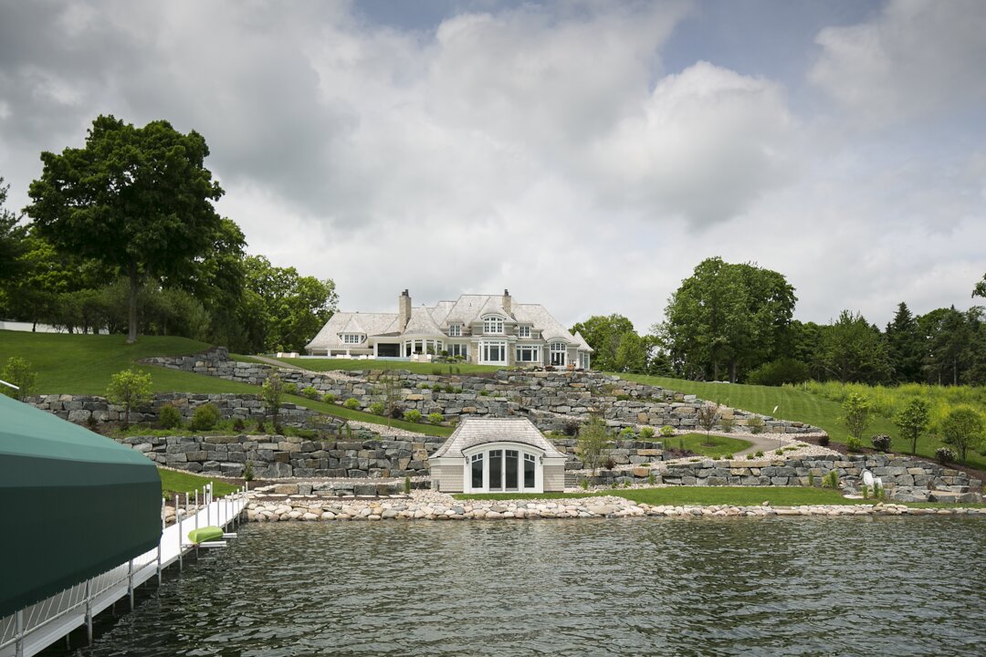 Lakeside estate with terraced landscaping and boathouse.