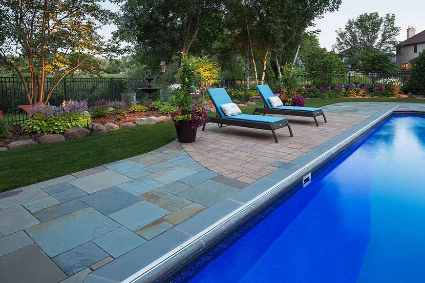Backyard pool with lounge chairs and garden.