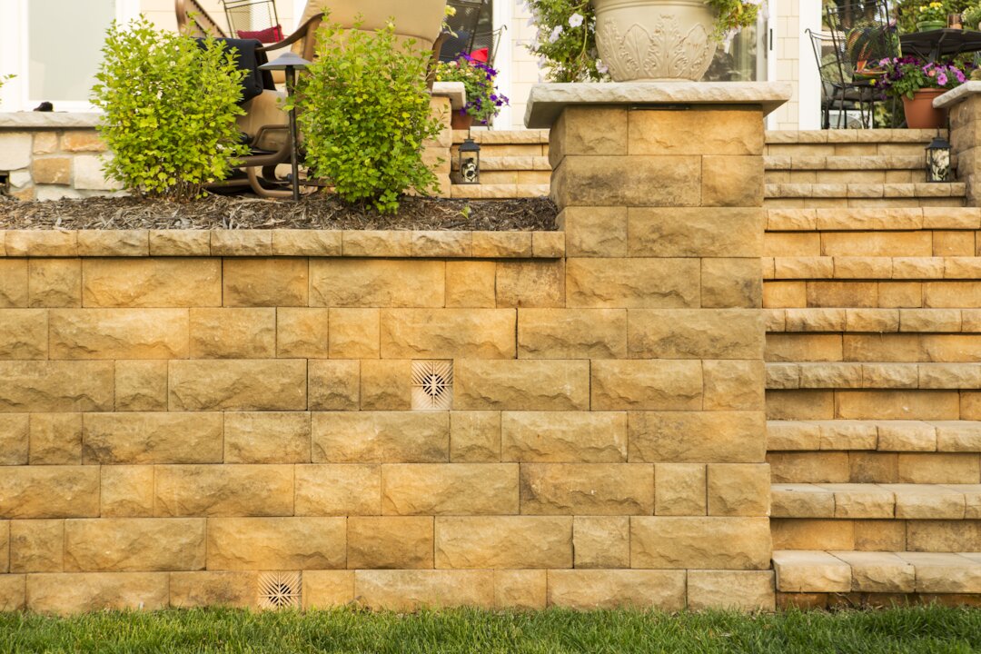 Stone retaining wall with plants and stairs