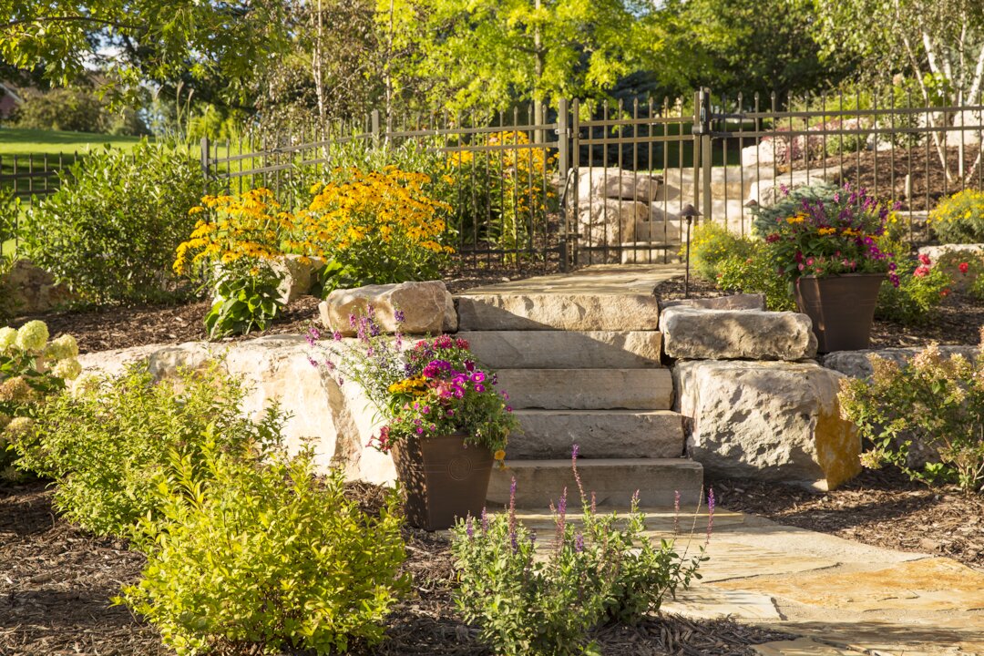 Garden with flowers, stones, and steps.