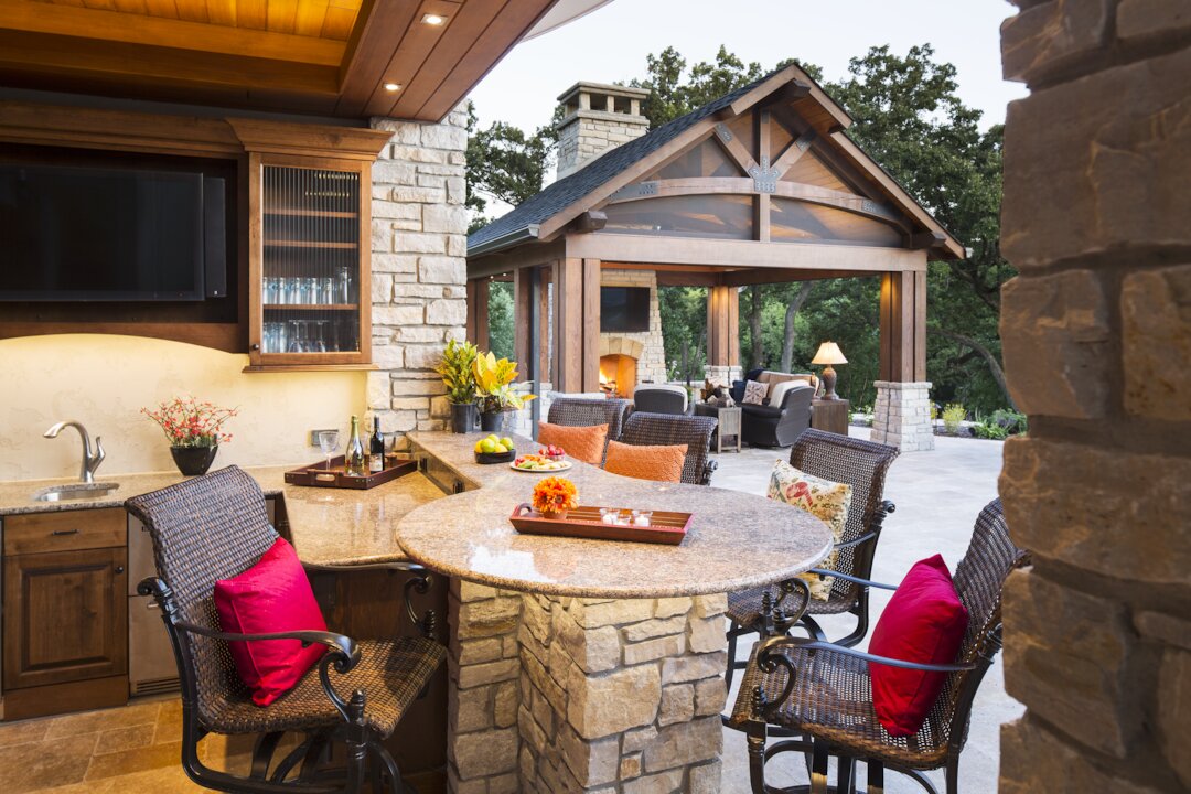 Outdoor kitchen and seating area with stone accents.