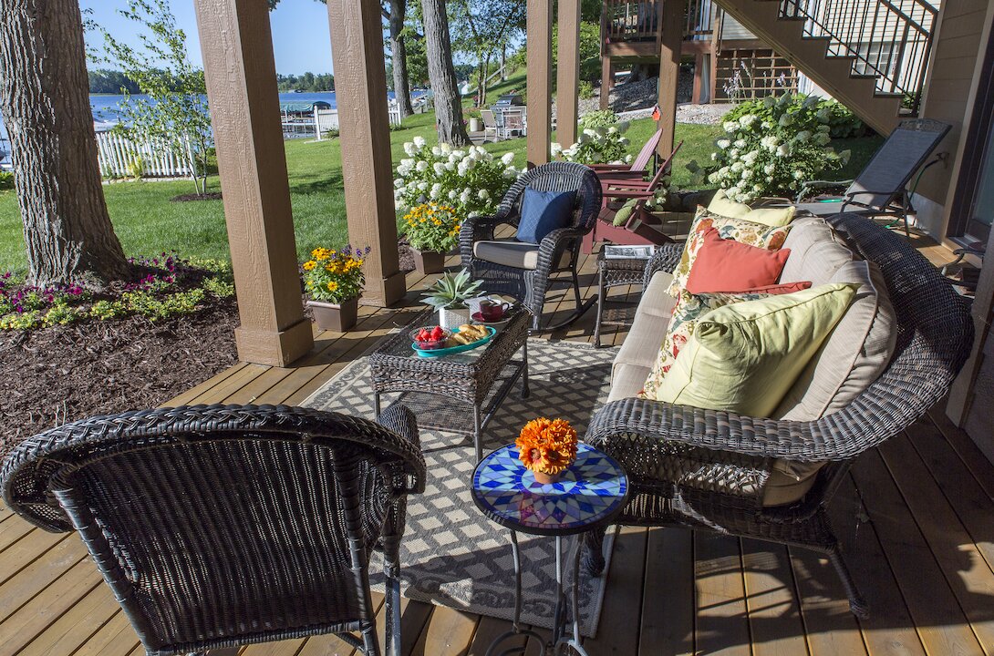 Cozy outdoor patio with wicker furniture and plants.