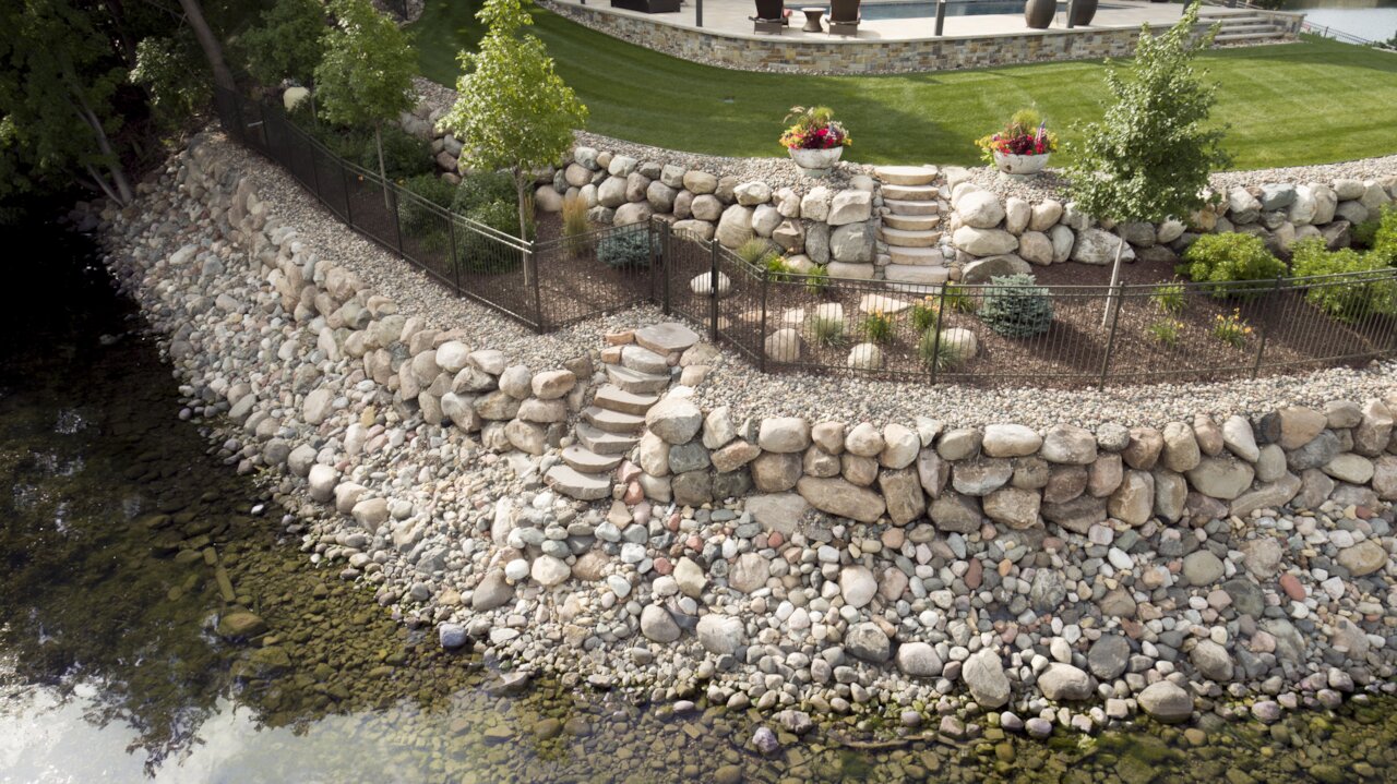 Terraced backyard with stone retaining walls and plants.