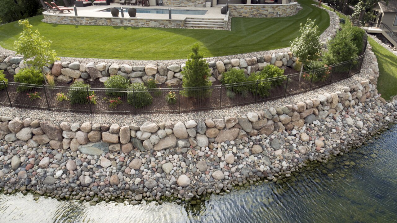 Tiered stone landscaping by a waterfront.