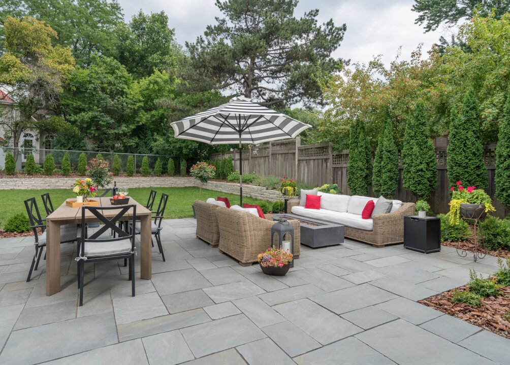 Cozy backyard patio with furniture and umbrella.