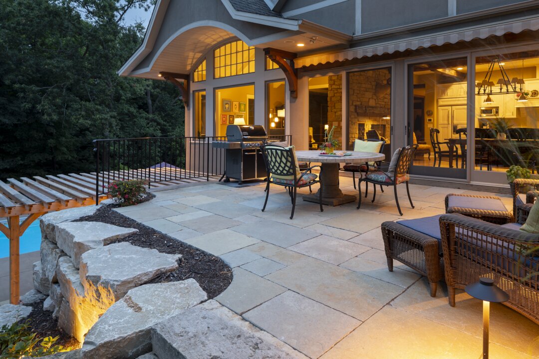 Cozy evening patio with furniture and grill.