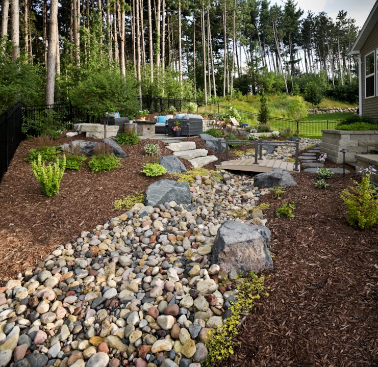 Beautiful landscaped backyard with rocks and greenery.