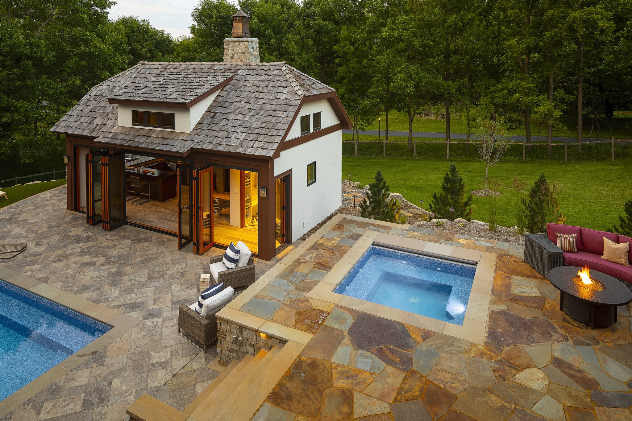Luxury poolside patio with fire pit.