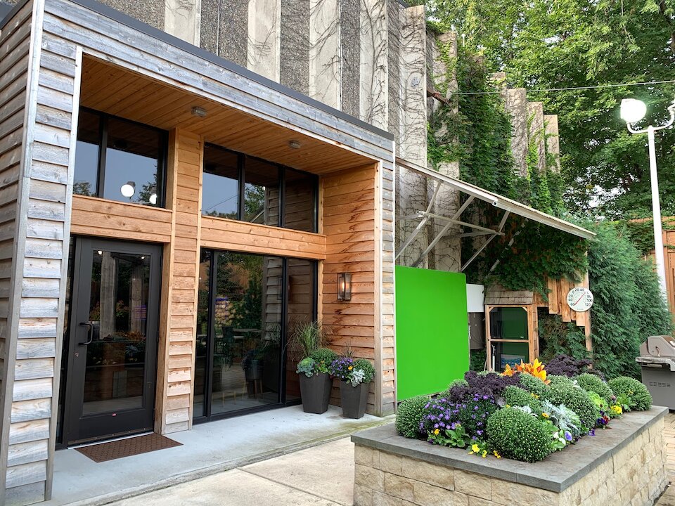 Modern building with plants and green screen display.