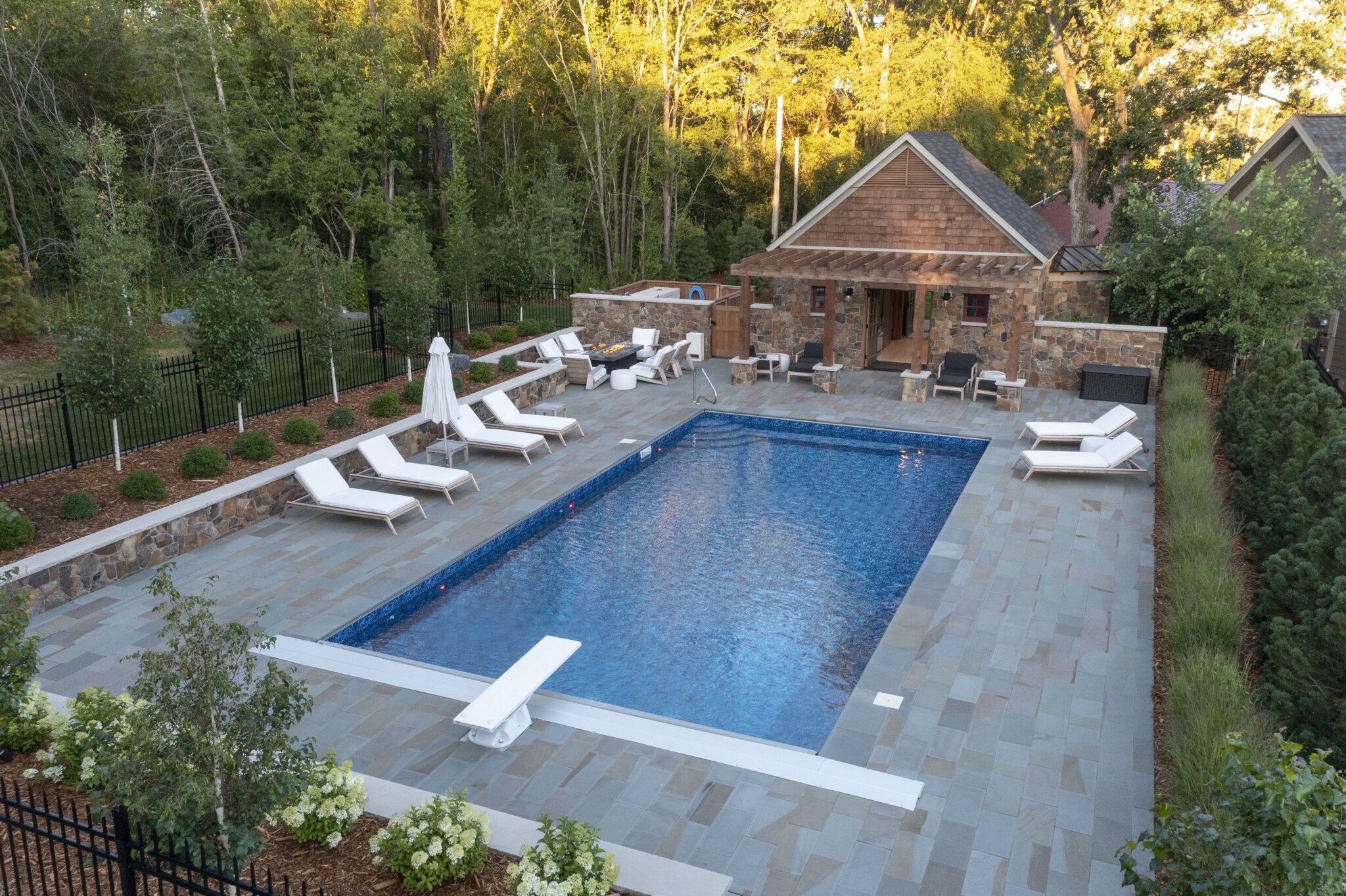 Luxurious backyard pool with lounge chairs and cabana.