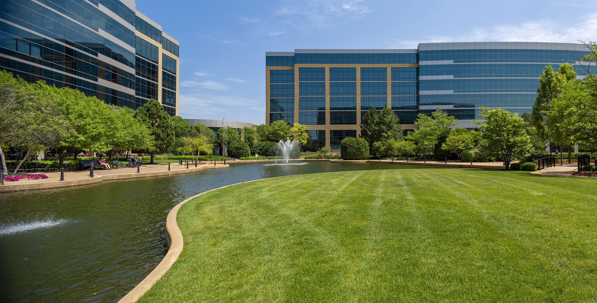 Office buildings with landscaped pond and fountain scene.