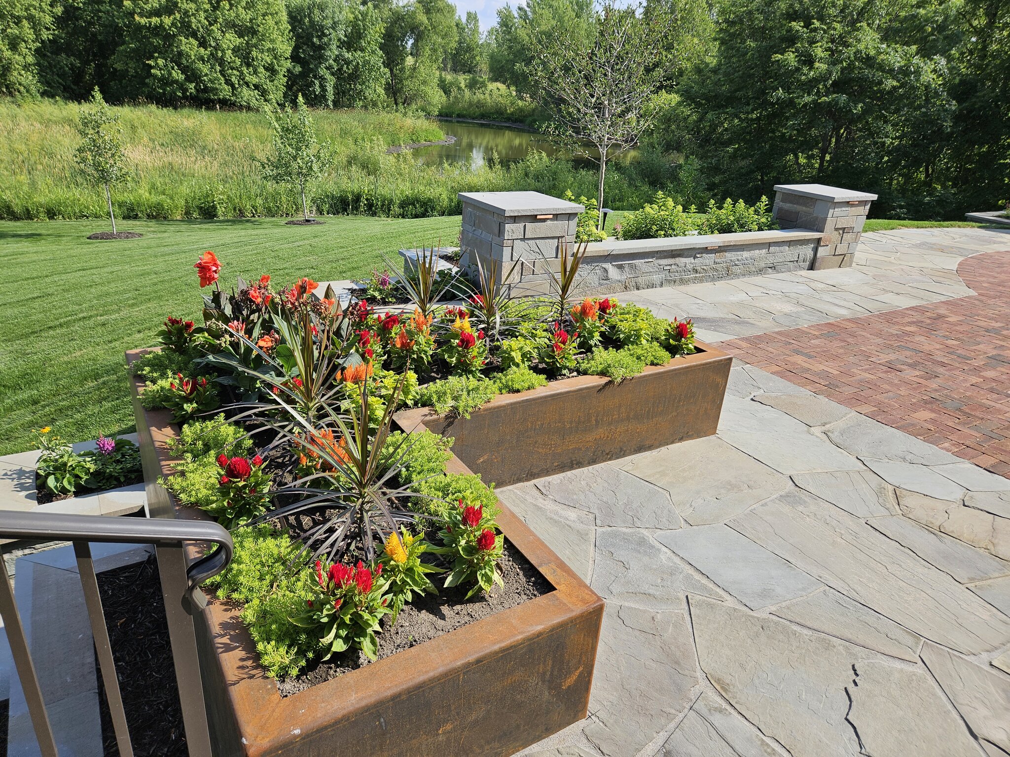 Colorful flower beds near serene pond landscape.