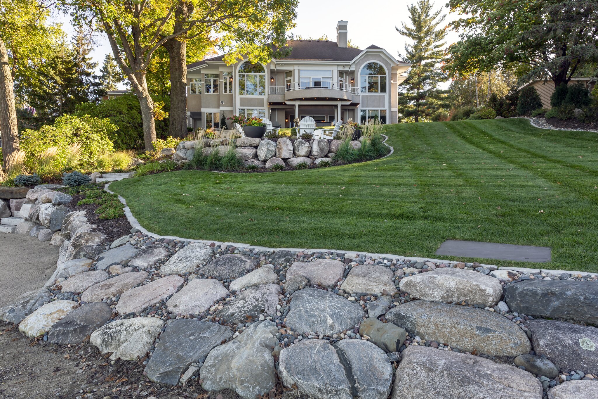 Spacious backyard with lush lawn and stone landscaping.