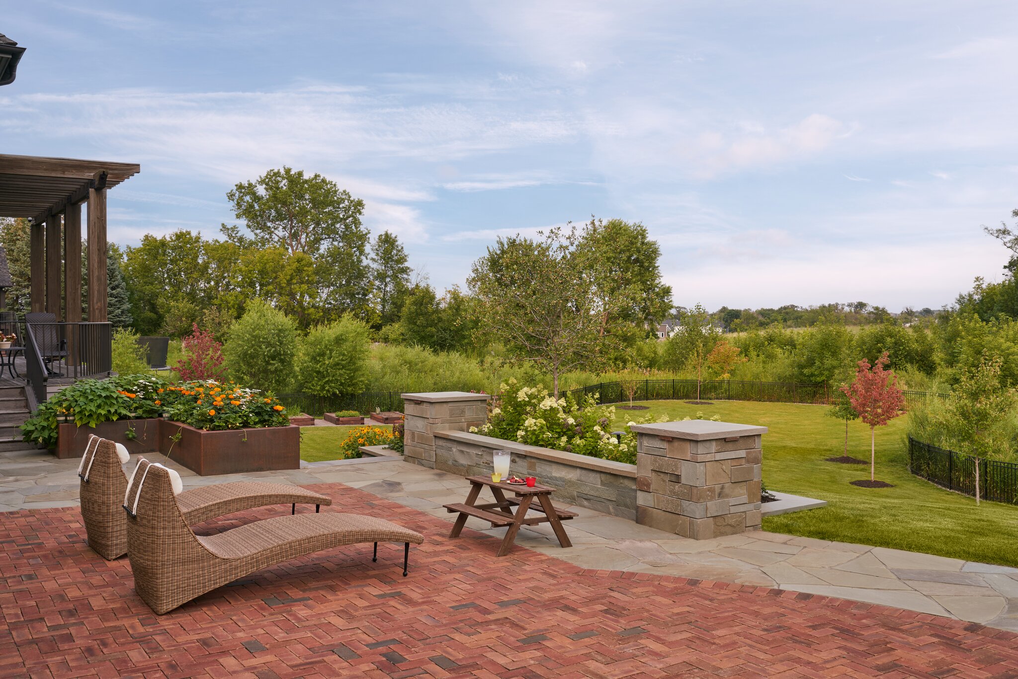 Beautiful patio with loungers and lush garden view.