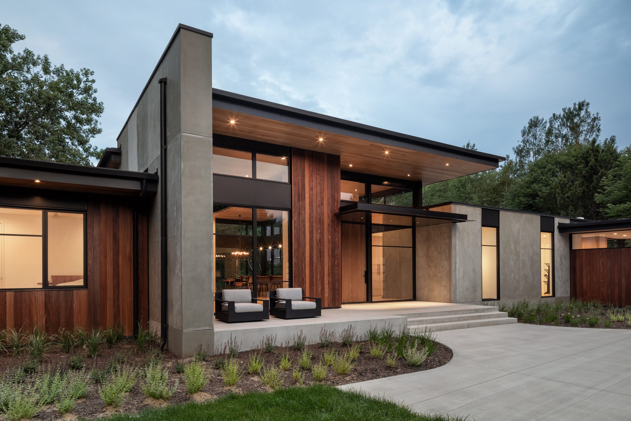 Modern house with large windows and garden.