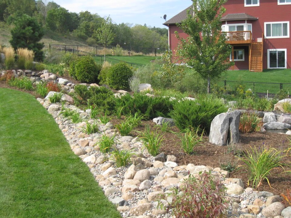 Beautiful garden with rock landscaping near house.