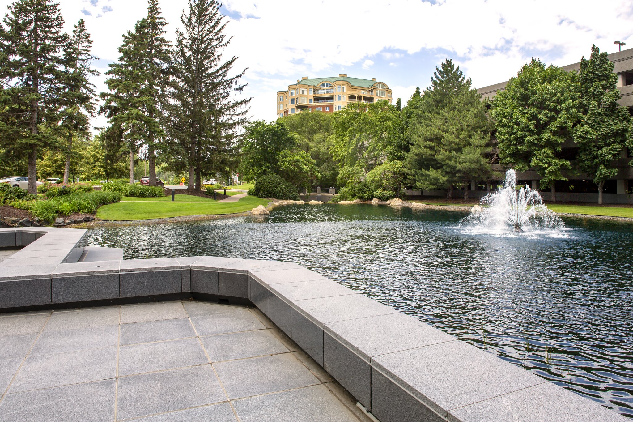 Park with fountain, trees, and building in background.