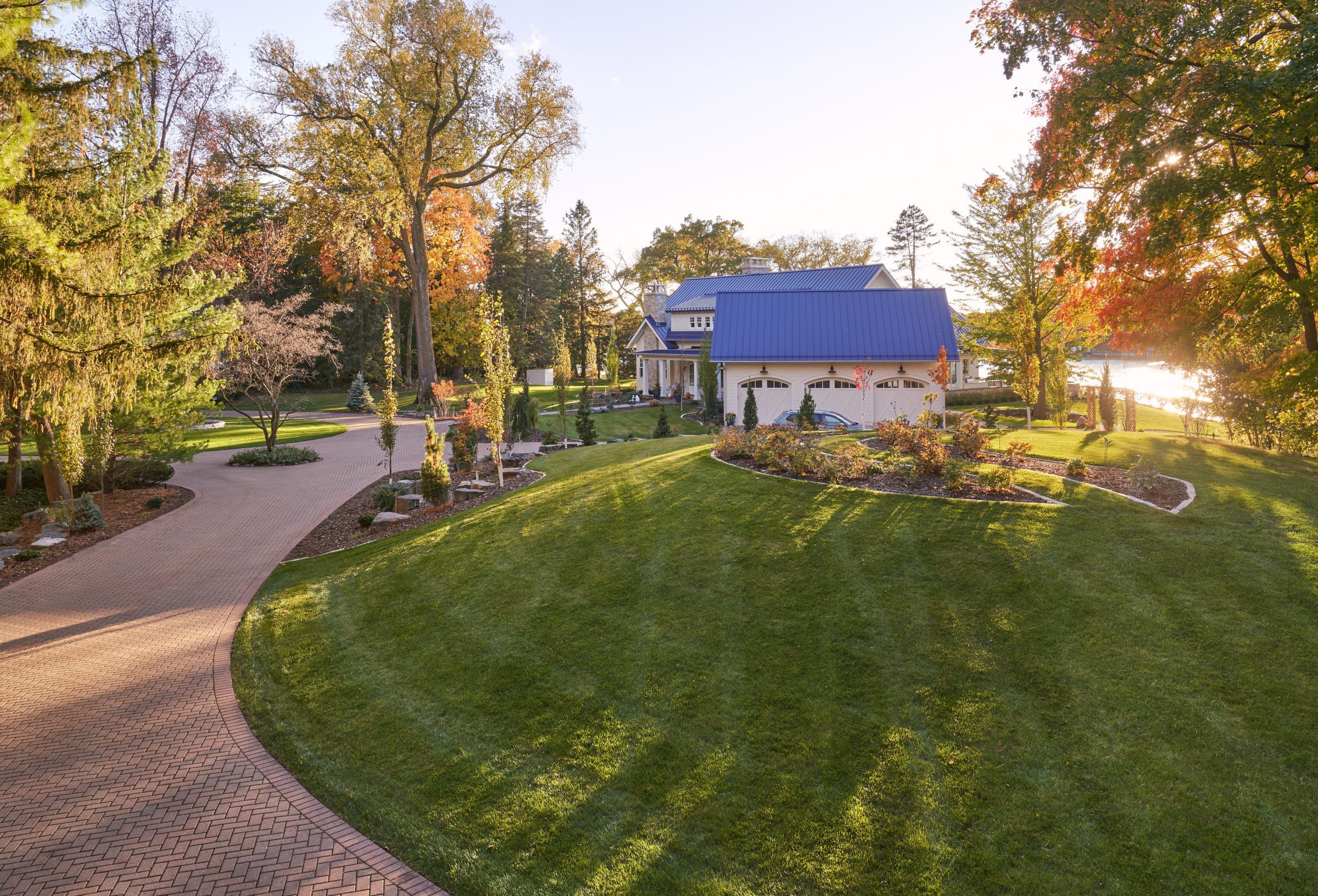 Large house with landscaped yard in autumn setting.