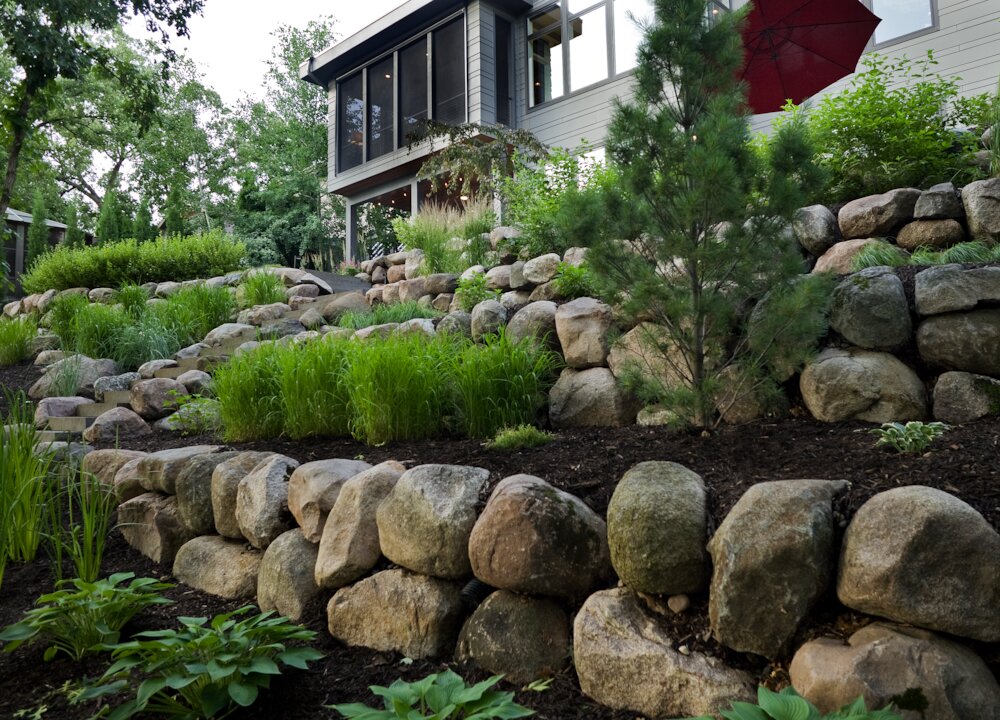 Stone retaining wall with lush garden landscape
