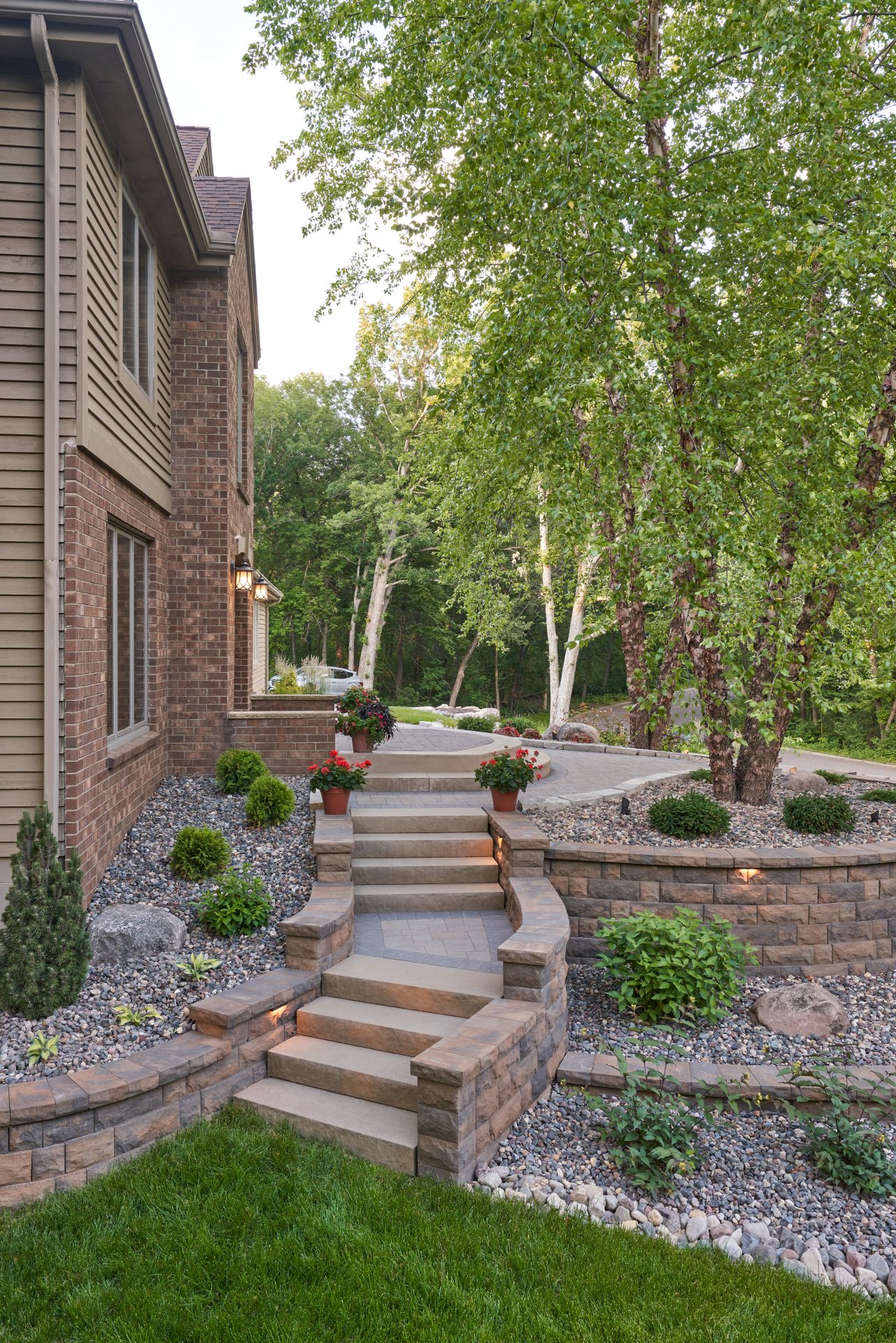 Brick house with landscaped garden and stone walkway.