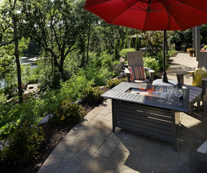 Patio with chairs, fire pit, and red umbrella
