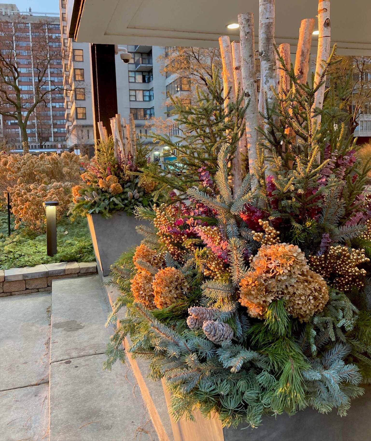 Colorful winter floral arrangement with foliage and branches.