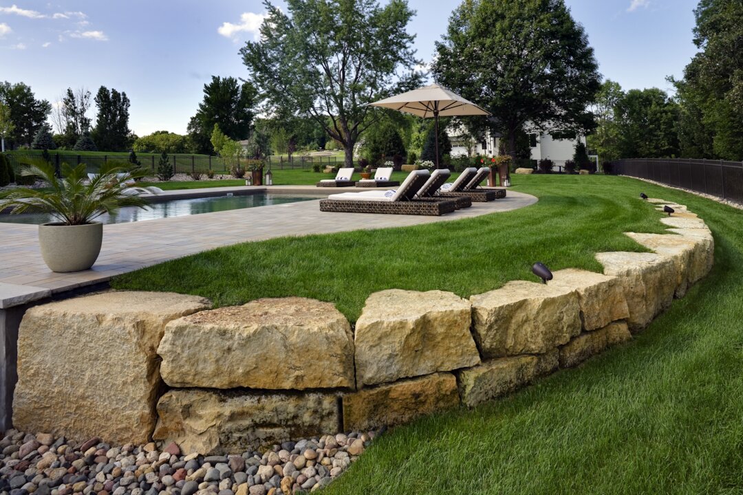 Luxury backyard pool with lounge chairs and landscaping