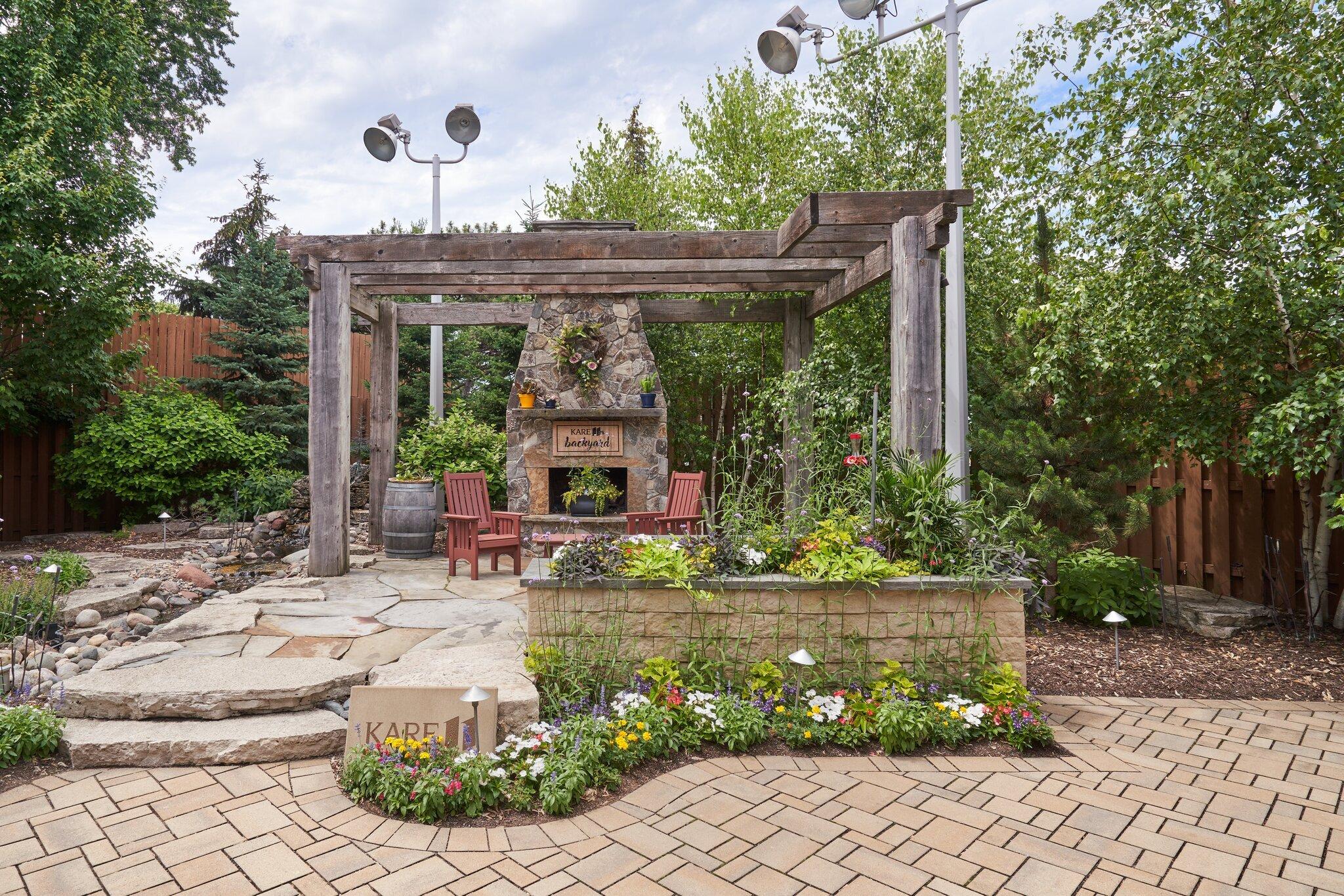 Outdoor patio with fireplace and garden landscaping and spotlights for TV broadcast