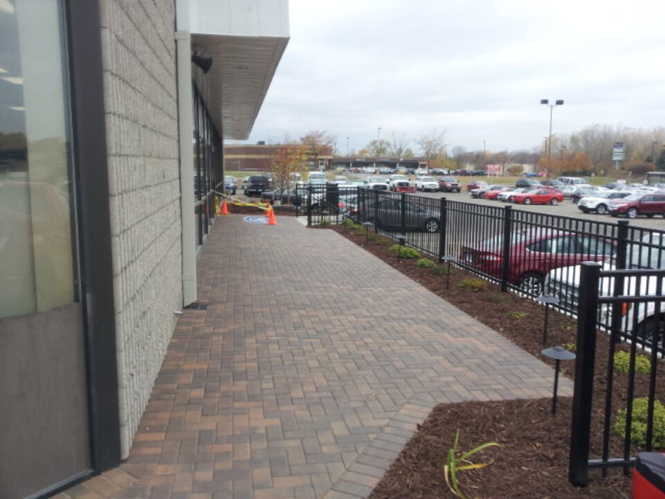 Sidewalk next to parking lot and building entrance.