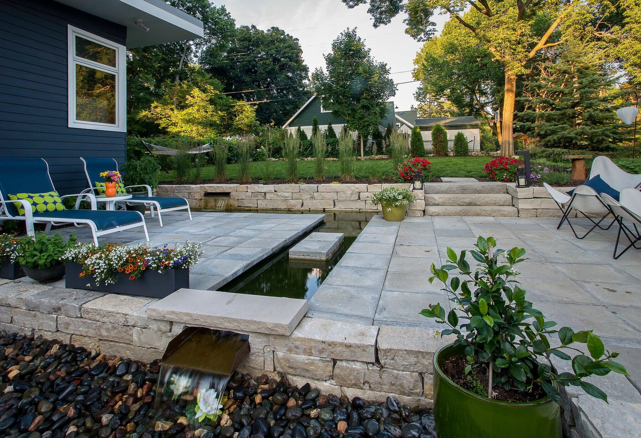 Modern patio with plants and water feature.