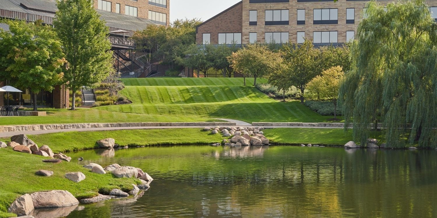 Office building with landscaped garden and pond.