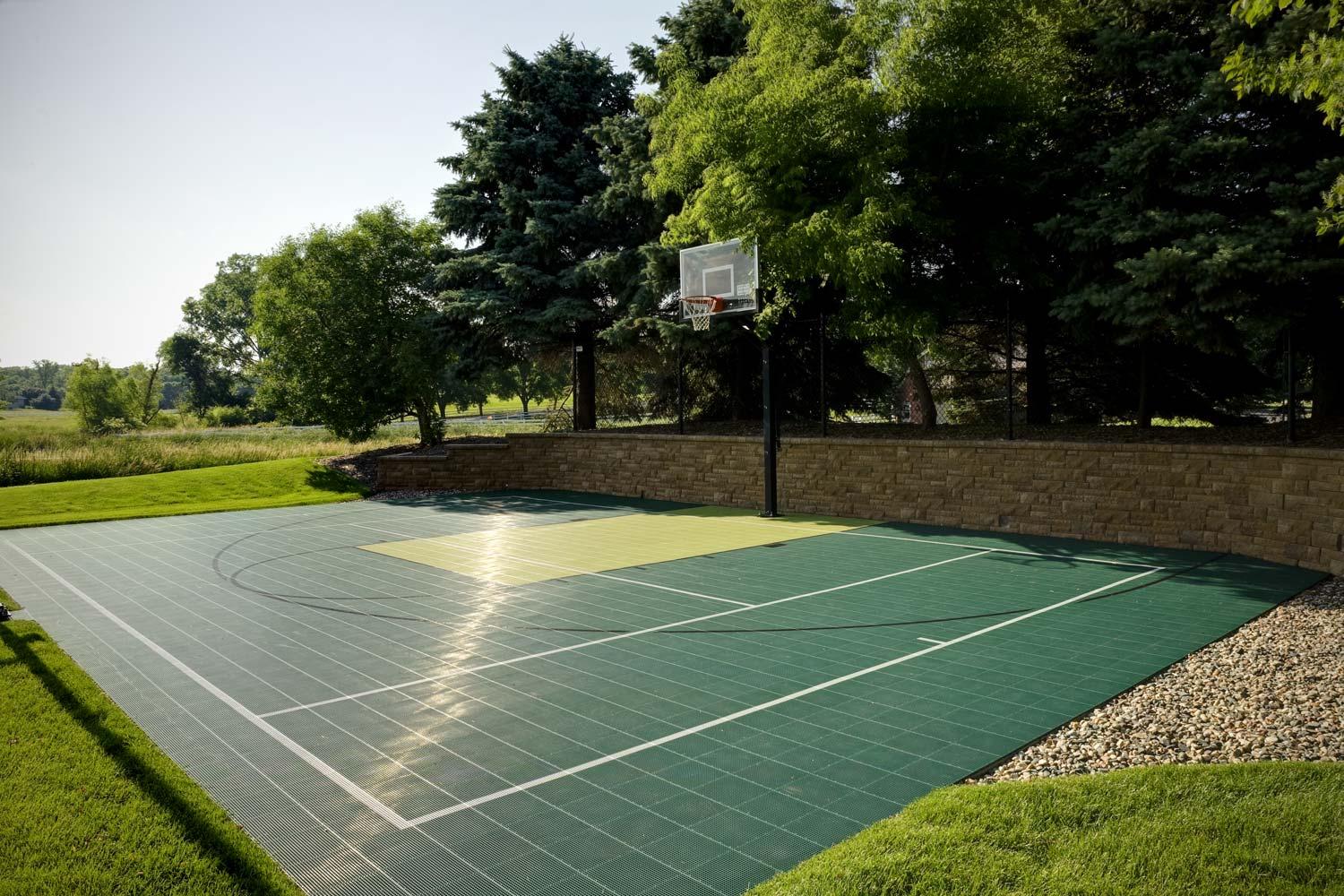 Outdoor basketball court with surrounding trees.