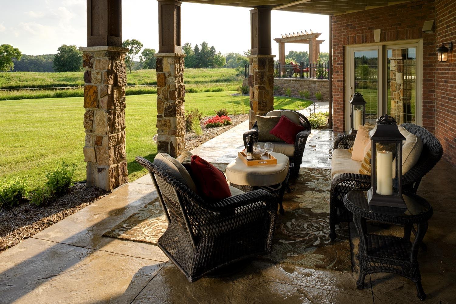 Cozy outdoor patio with wicker furniture and garden view.
