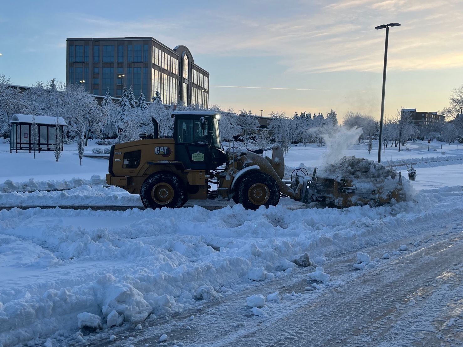 Snowplow clearing snowy road during winter morning.