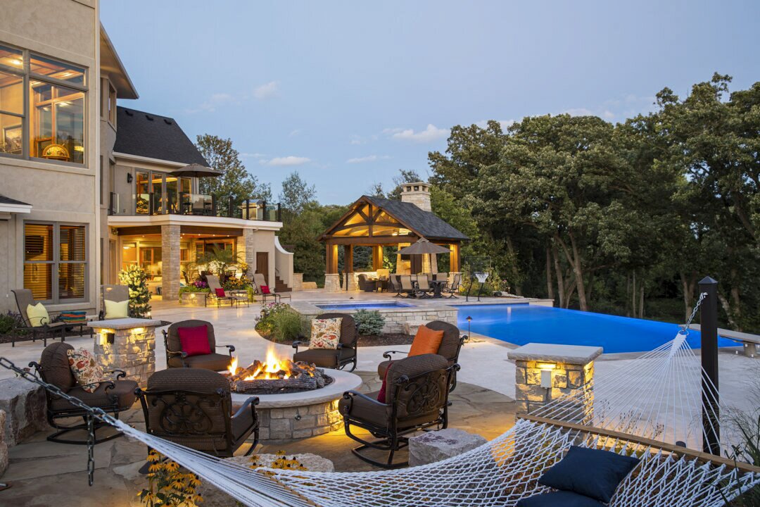 Luxurious patio with pool and fire pit.