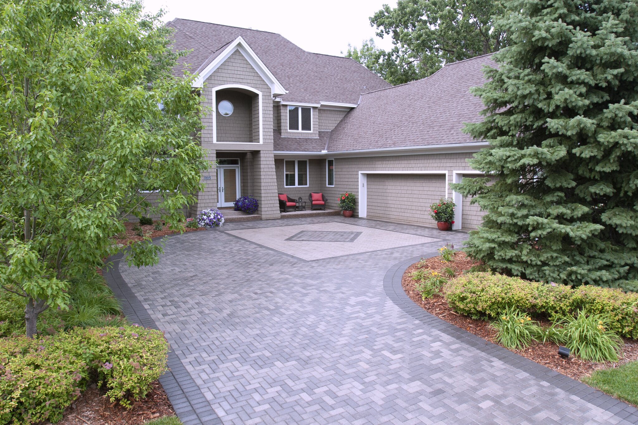 Modern house with brick driveway and landscaping