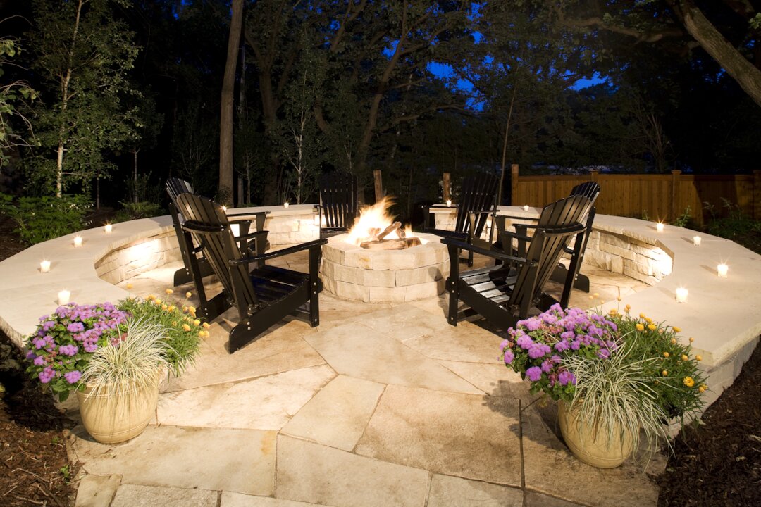 Cozy backyard fire pit with Adirondack chairs.