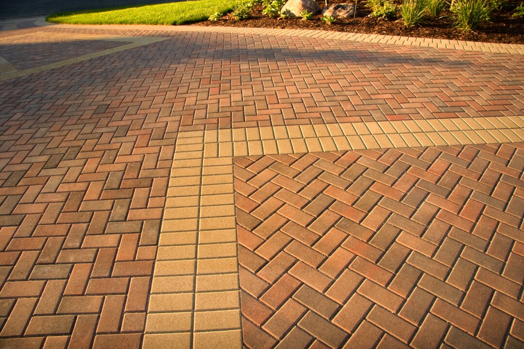 Patterned brick driveway with landscaping