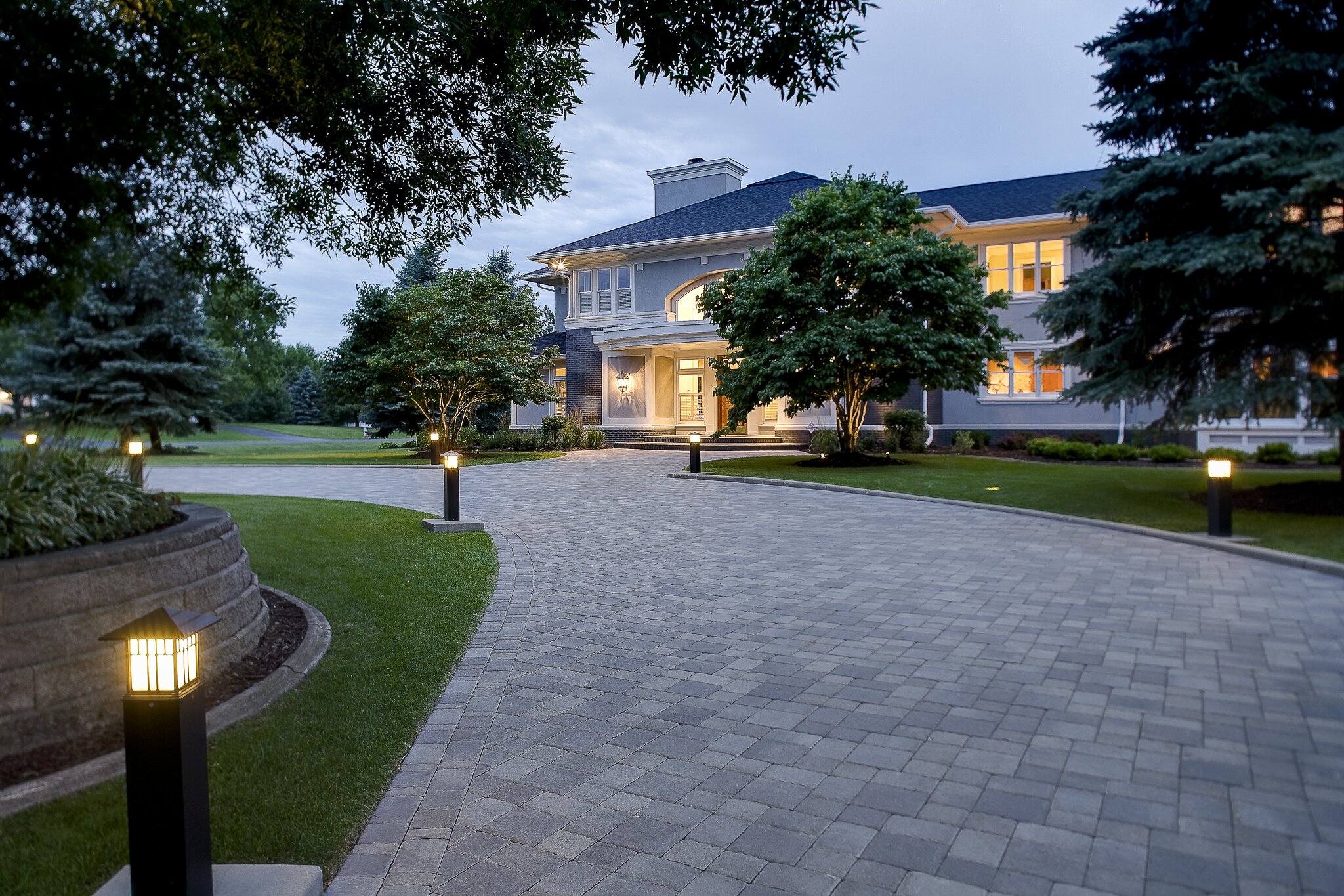 Elegant house with lit driveway at dusk