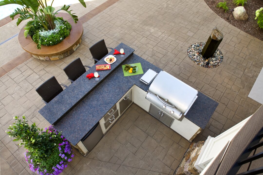 Outdoor patio with kitchen and dining area.