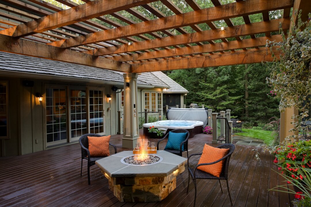 Cozy patio with firepit, chairs, and hot tub.