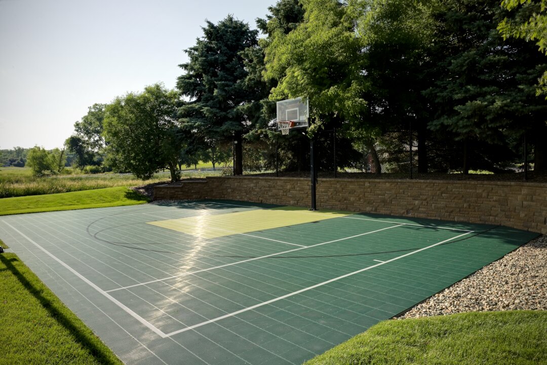 Outdoor basketball court with trees and greenery